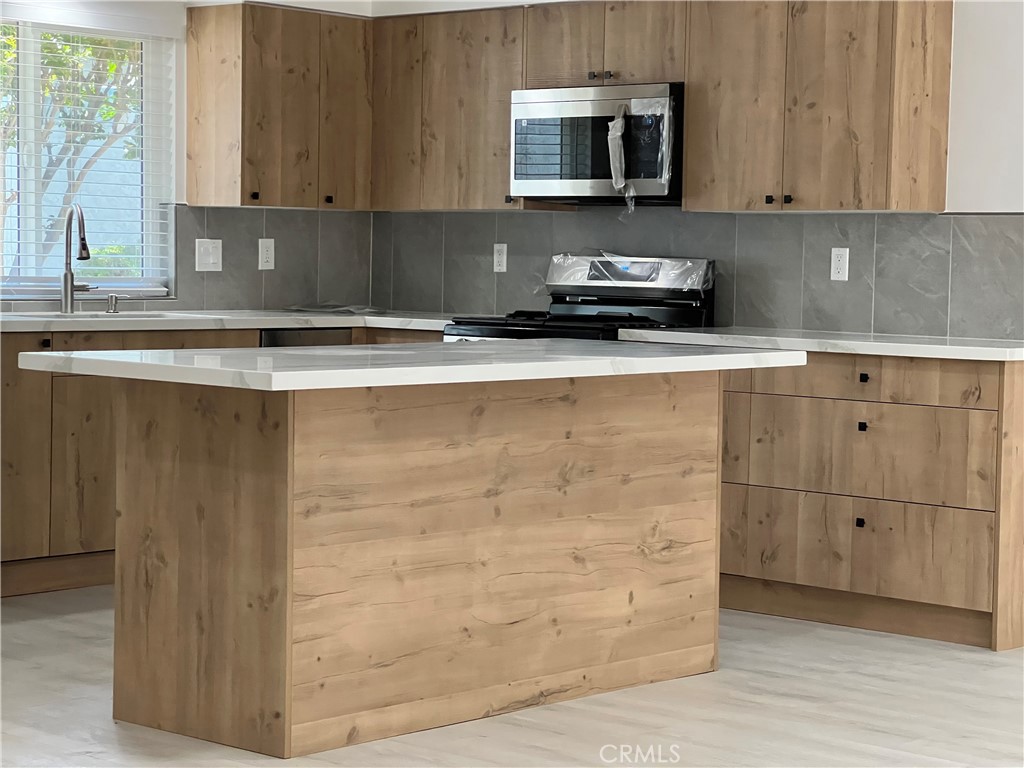 7561 Donna Avenue Reseda, CA 91335 - Photo 7 of 30 a kitchen with stainless steel appliances granite countertop a sink a stove and a microwave