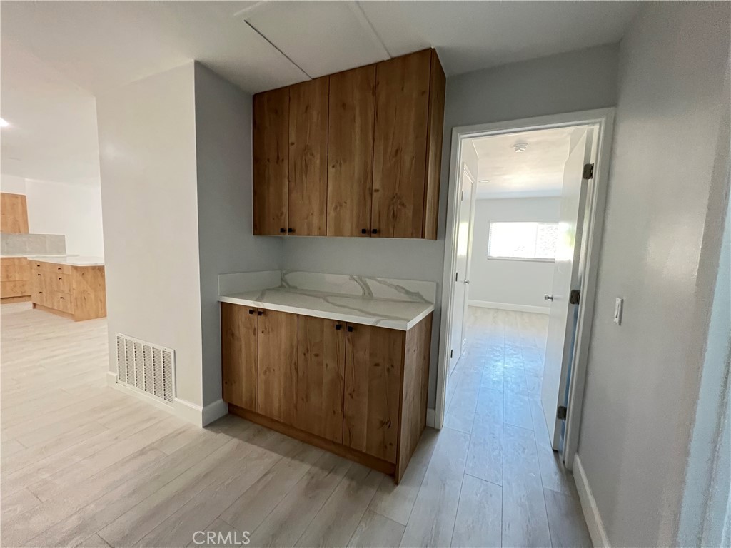 7561 Donna Avenue Reseda, CA 91335 - Photo 10 of 30 a hallway with wooden floor and cabinet