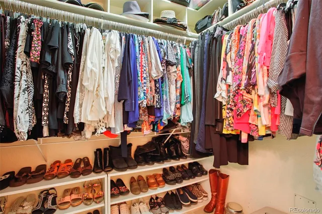 a view of walk in closet with clothes and shoes