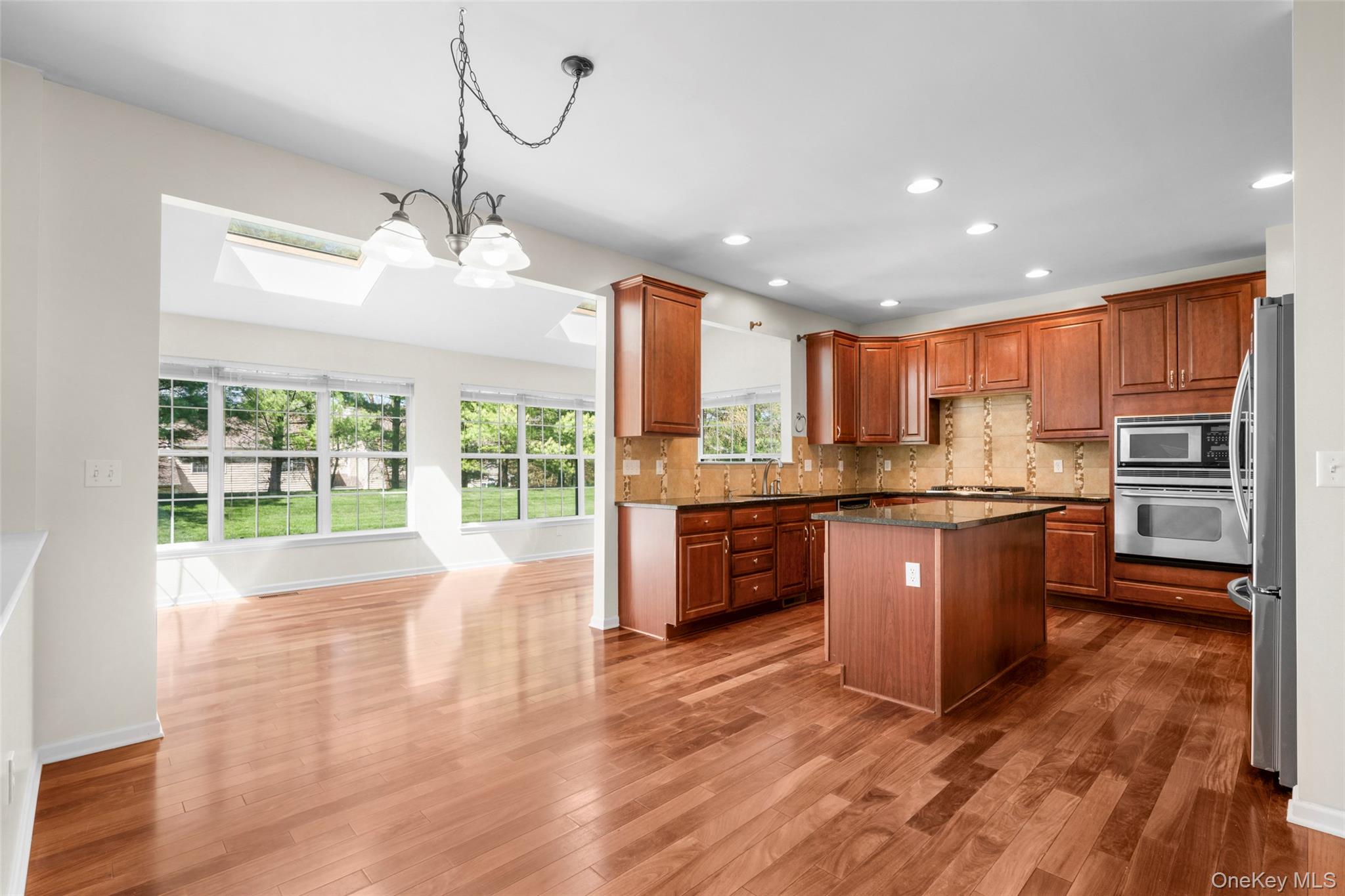 411 Vassar Place Fishkill, NY 12524 - Photo 5 of 39 a large kitchen with kitchen island granite countertop a large window and stainless steel appliances
