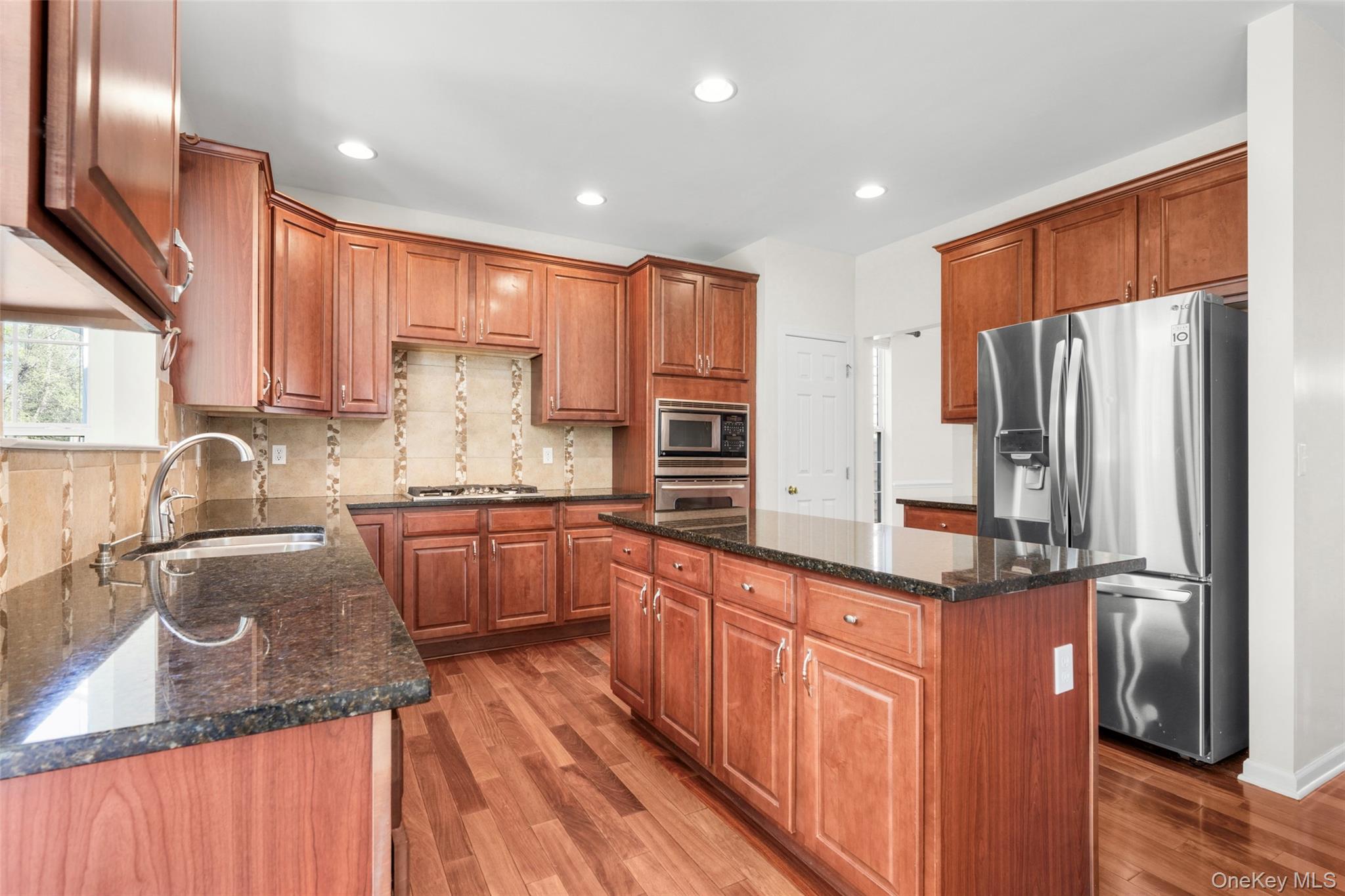411 Vassar Place Fishkill, NY 12524 - Photo 6 of 39 a kitchen with stainless steel appliances granite countertop a refrigerator a sink dishwasher a stove and white countertops with wooden floor