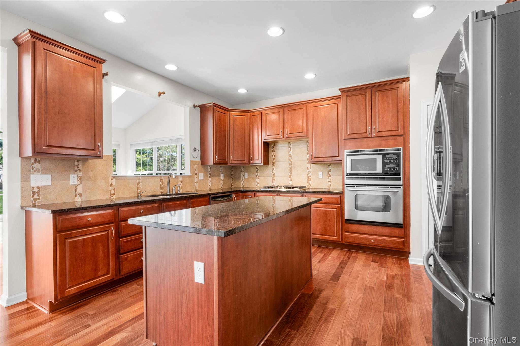411 Vassar Place Fishkill, NY 12524 - Photo 7 of 39 a kitchen with stainless steel appliances granite countertop a refrigerator a sink dishwasher a stove with wooden cabinets and floor