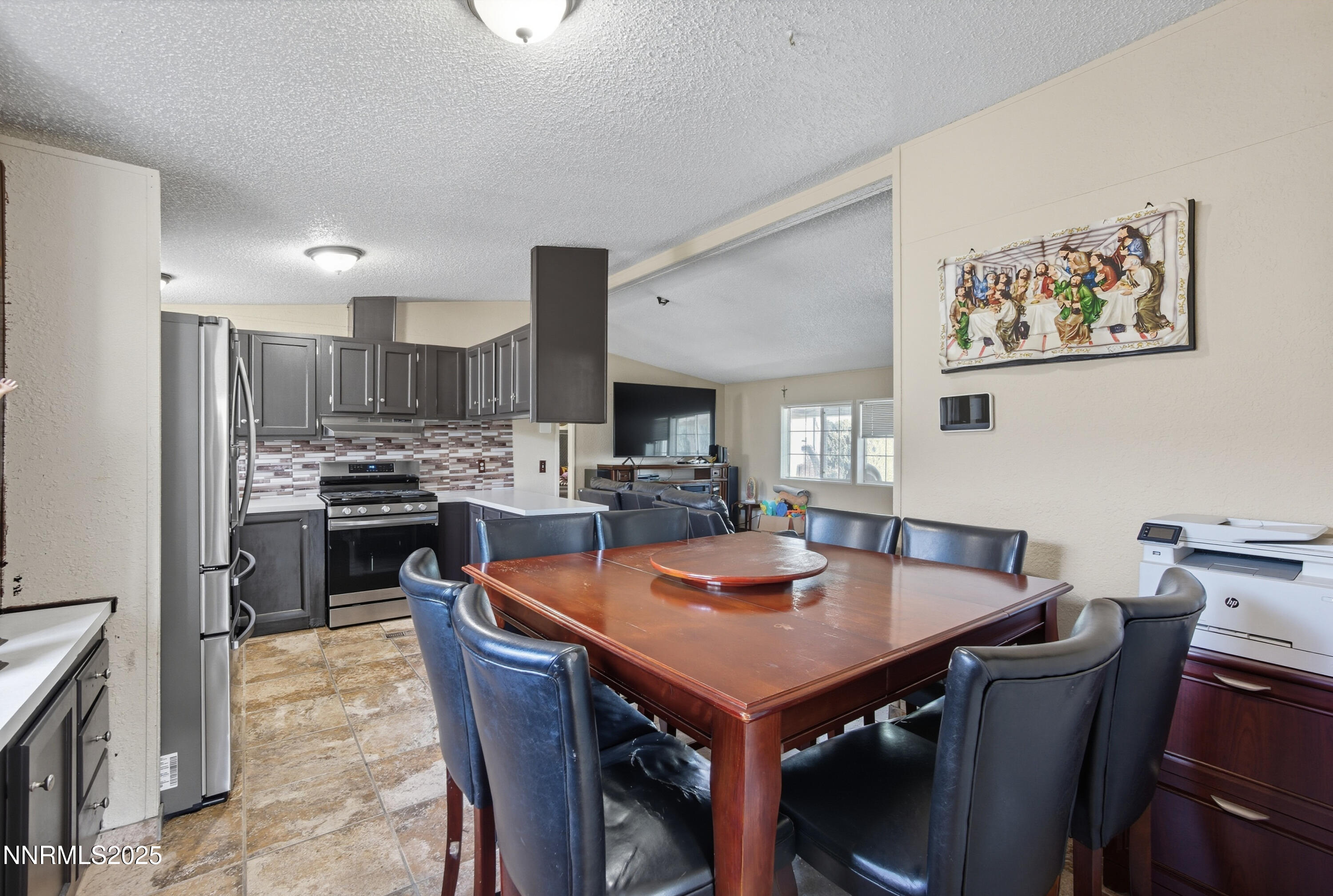 2135 Barberry Way Reno, NV 89512 - Photo 5 of 16 a kitchen with a table a refrigerator a stove a dining table and chairs