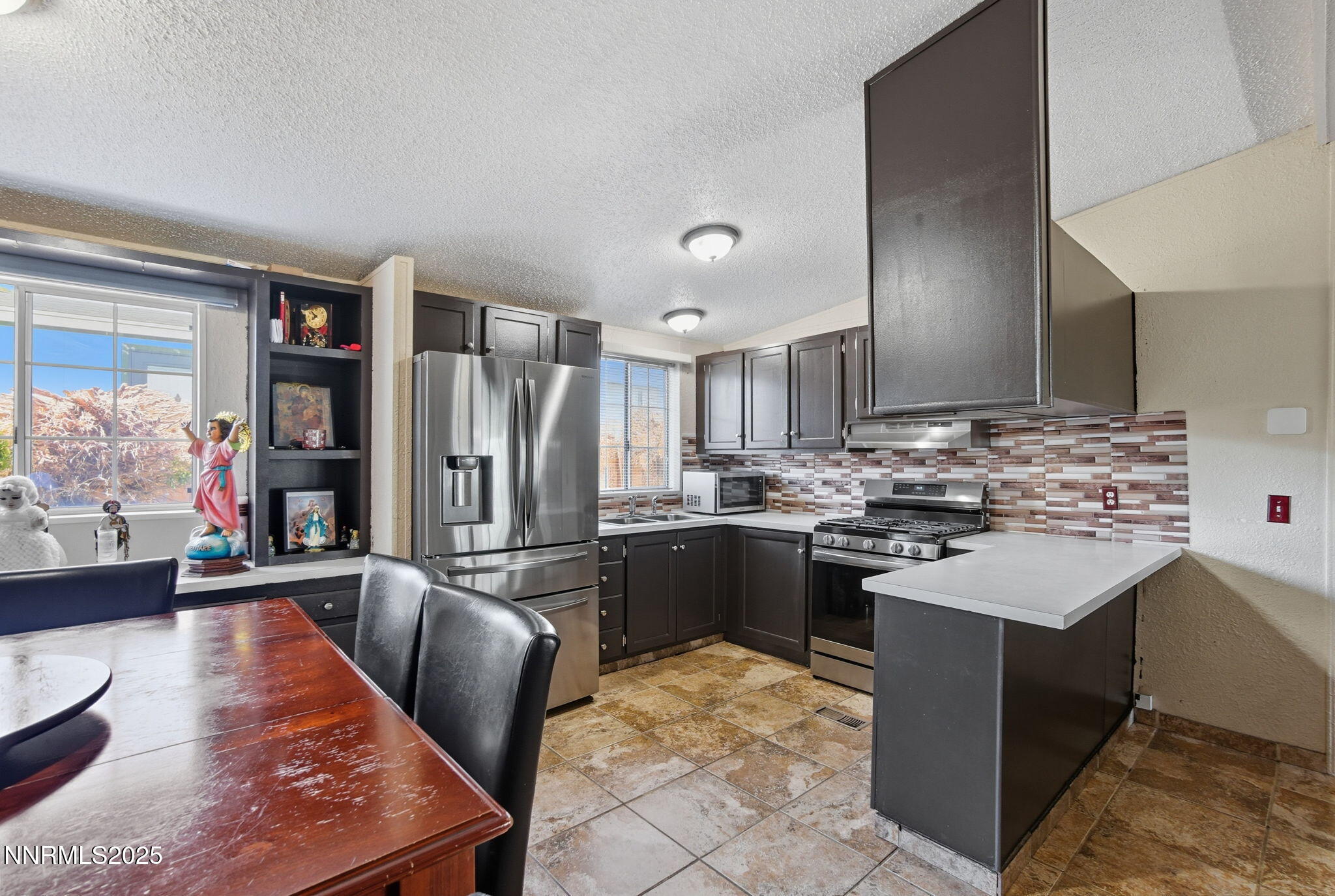 2135 Barberry Way Reno, NV 89512 - Photo 7 of 16 a kitchen with stainless steel appliances granite countertop a sink stove and refrigerator