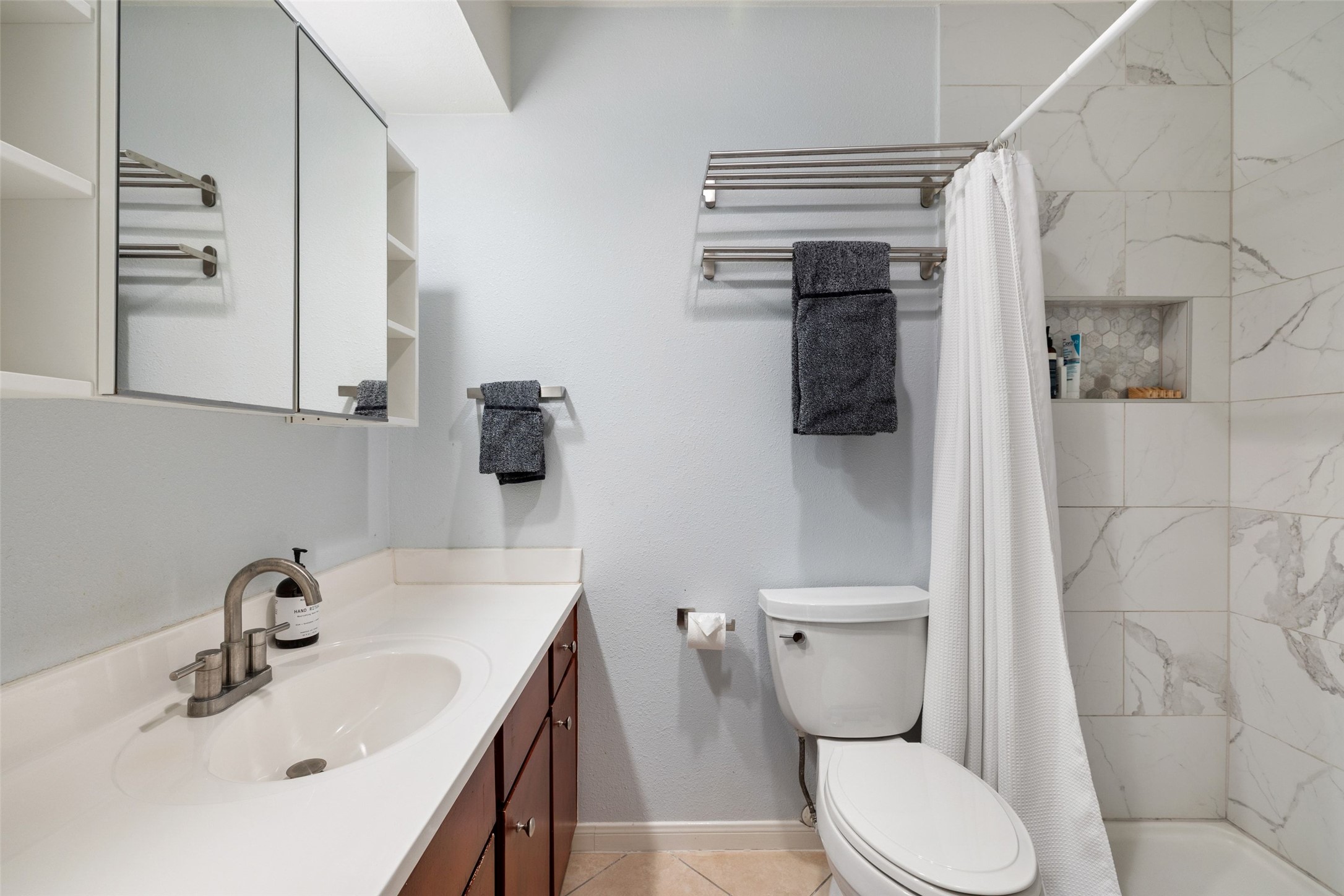 830 Banister Lane Austin, TX 78704 - Photo 13 of 38 Upstairs full bathroom with storage and updated full tile surround walk-in shower