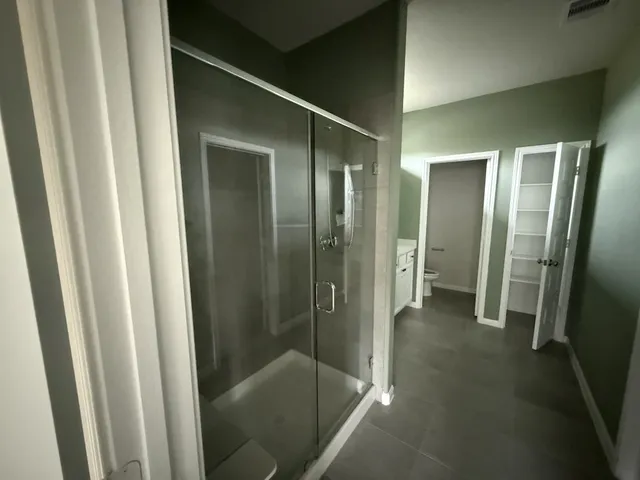 a bathroom with a shower and a glass door