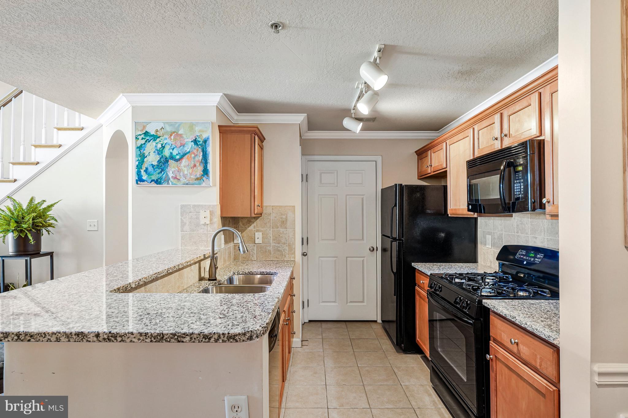 503 Sunset View Terrace Southeast, Unit 407 Leesburg, VA 20175 - Photo 11 of 35 a kitchen with stainless steel appliances granite countertop a sink stove and refrigerator