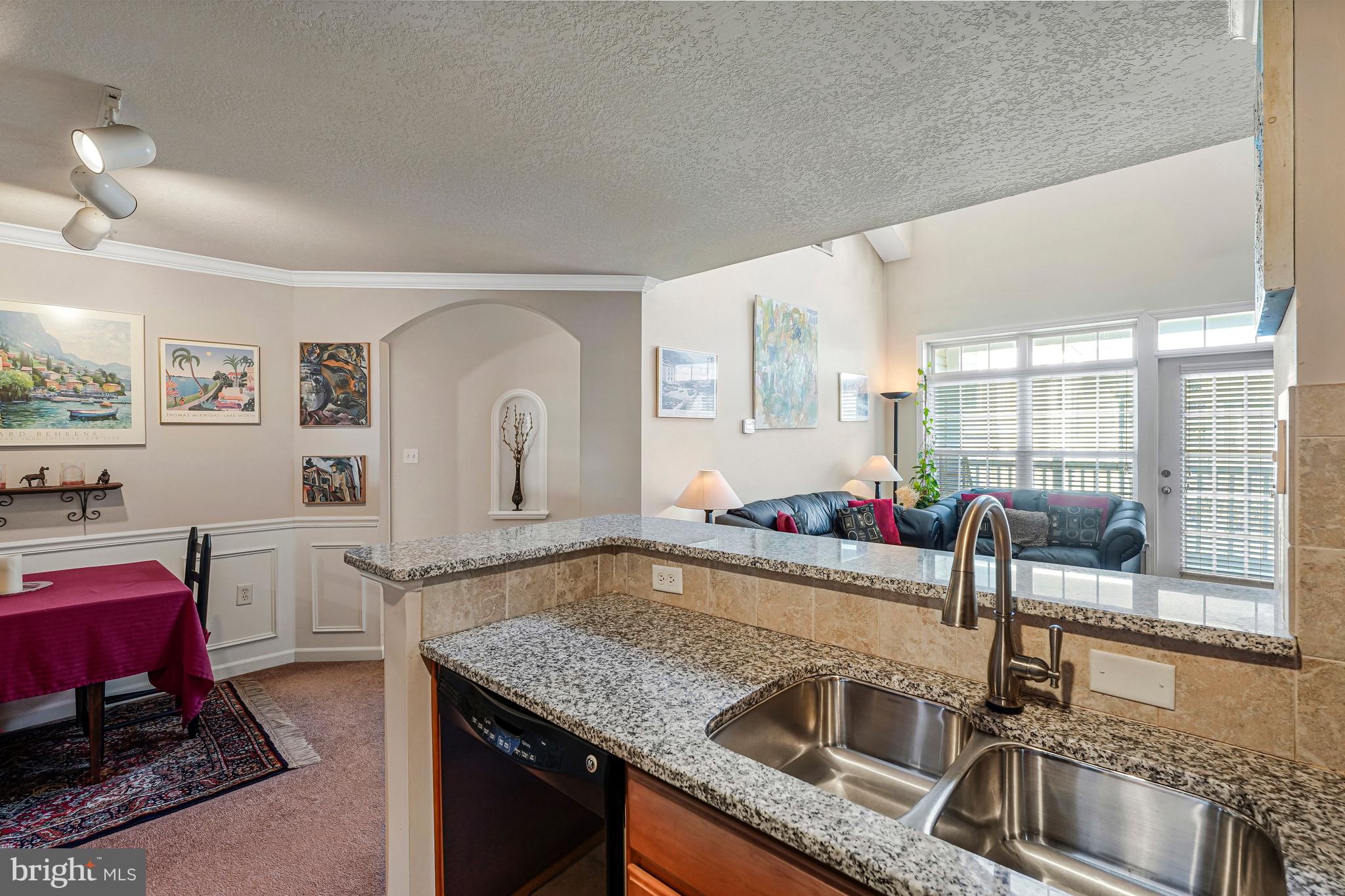 503 Sunset View Terrace Southeast, Unit 407 Leesburg, VA 20175 - Photo 13 of 35 a kitchen with granite countertop a sink a counter top space and stainless steel appliances