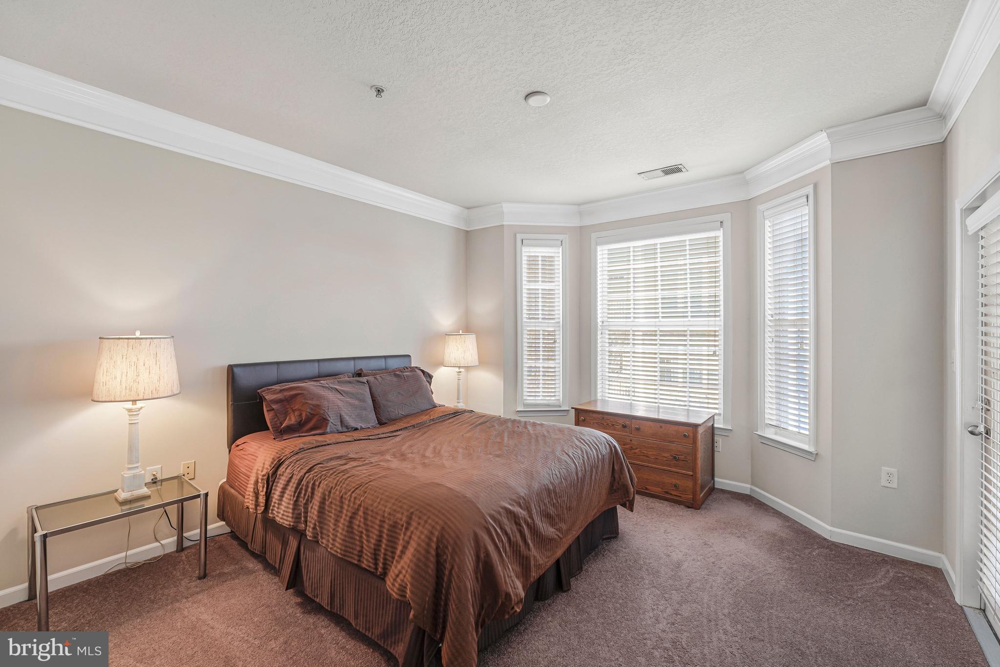 503 Sunset View Terrace Southeast, Unit 407 Leesburg, VA 20175 - Photo 21 of 35 a bedroom with a bed and a night stand