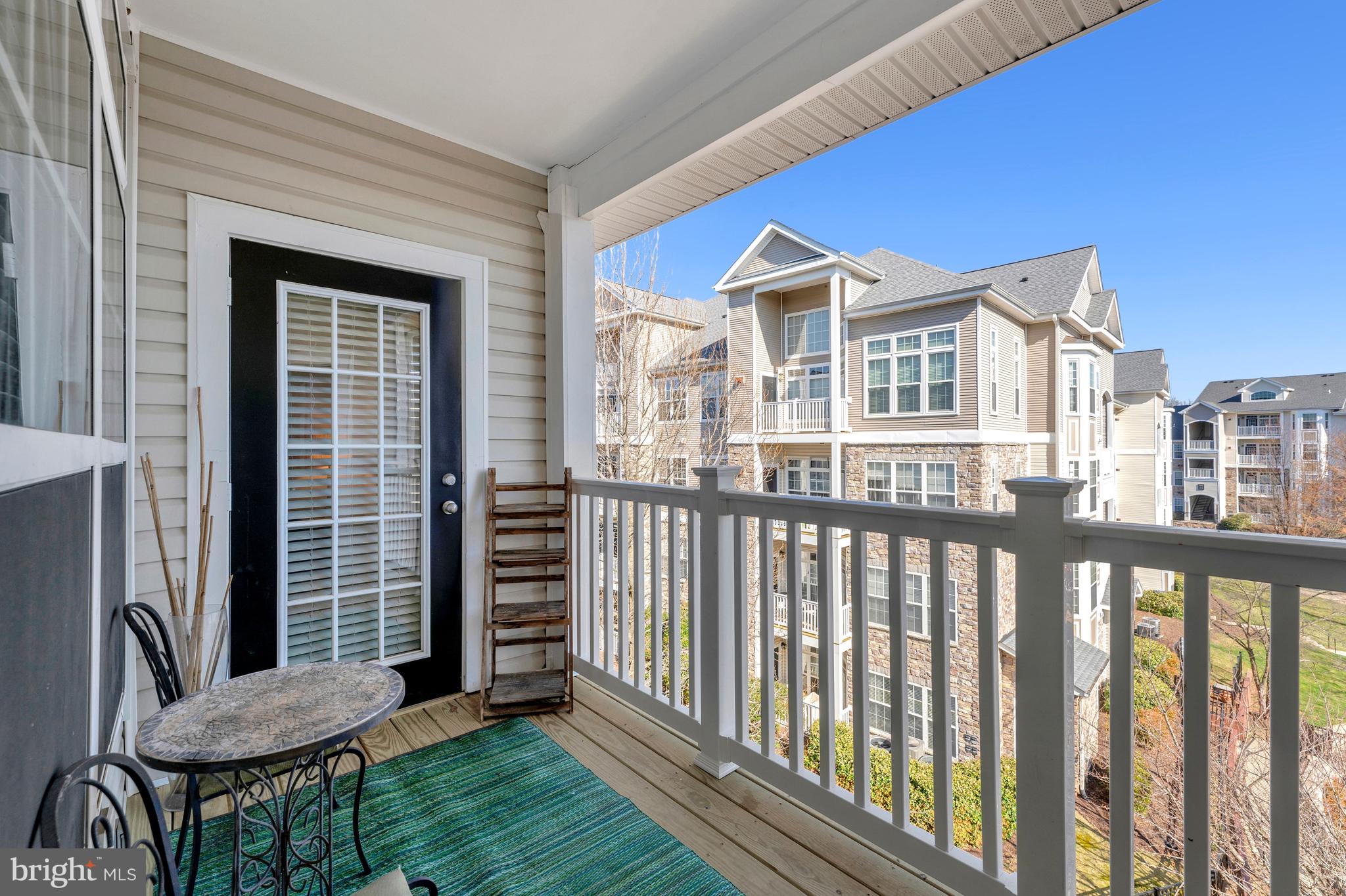 503 Sunset View Terrace Southeast, Unit 407 Leesburg, VA 20175 - Photo 24 of 35 a view of a brick house with a chairs and a table in a balcony