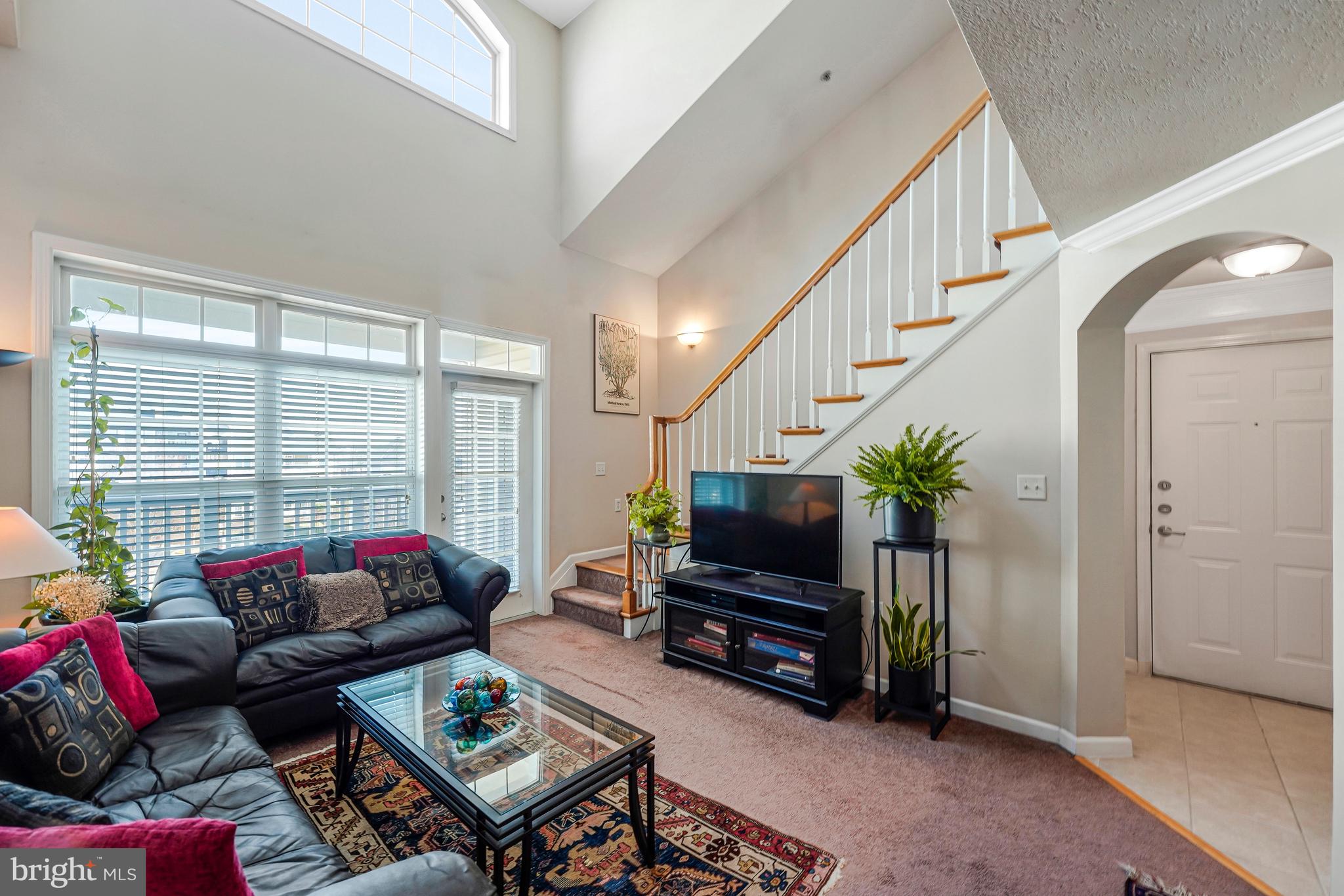 503 Sunset View Terrace Southeast, Unit 407 Leesburg, VA 20175 - Photo 6 of 35 a living room with furniture a flat screen tv and a floor to ceiling window