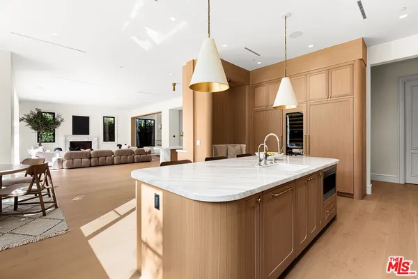 a dining hall with stainless steel appliances kitchen island a chandelier