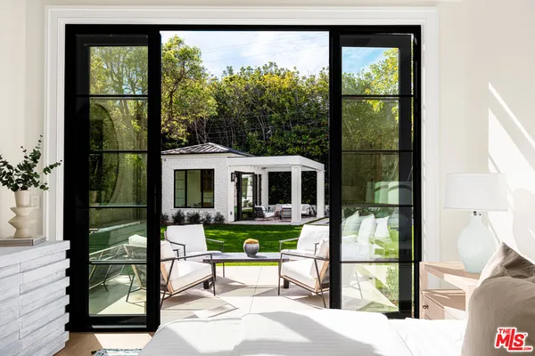 a living room with furniture and a floor to ceiling window