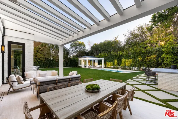 a view of a patio with couches table and chairs and potted plants