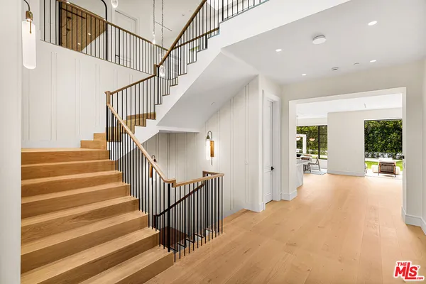 a view of staircase with lots of frames on wall and a large window