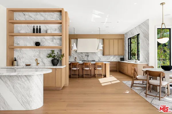 a large kitchen with kitchen island a large counter space and stainless steel appliances