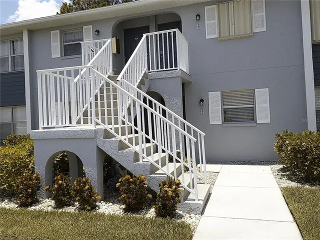 a view of a house with a small yard and flower plants