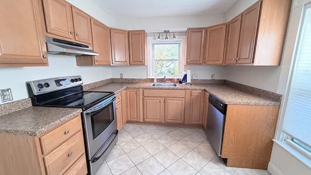 a kitchen with stainless steel appliances granite countertop a sink stove and microwave