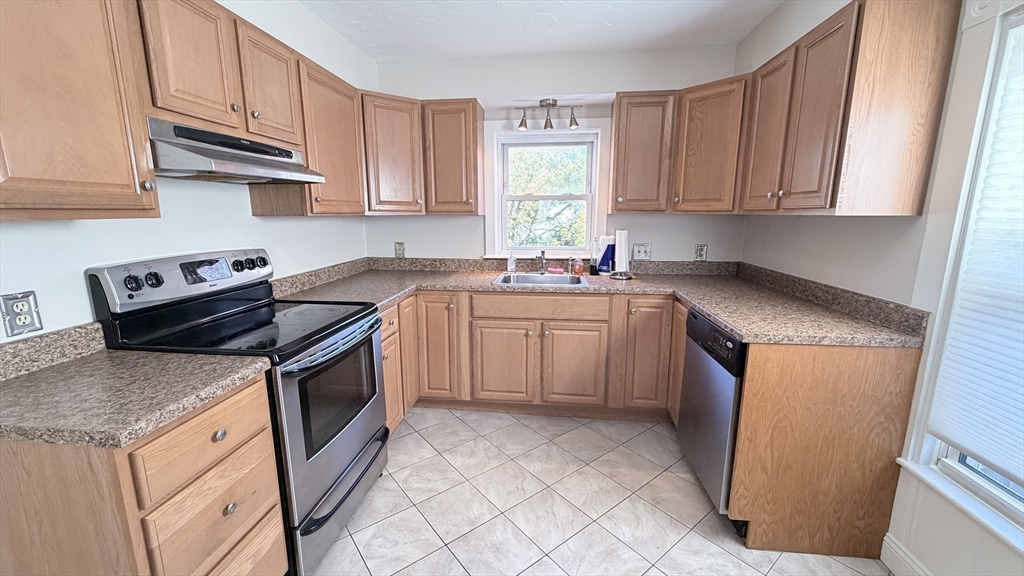 391 Commercial Street Braintree, MA 02184 - Photo 2 of 21 a kitchen with stainless steel appliances granite countertop a sink stove and microwave
