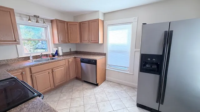 a kitchen with a sink refrigerator and window