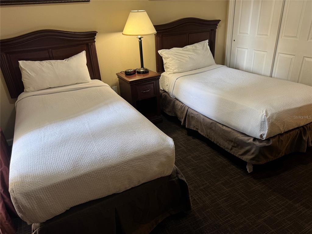 8762 Worldquest Boulevard, Unit 6203 Orlando, FL 32821 - Photo 12 of 31 a bedroom with a bed and two lamp