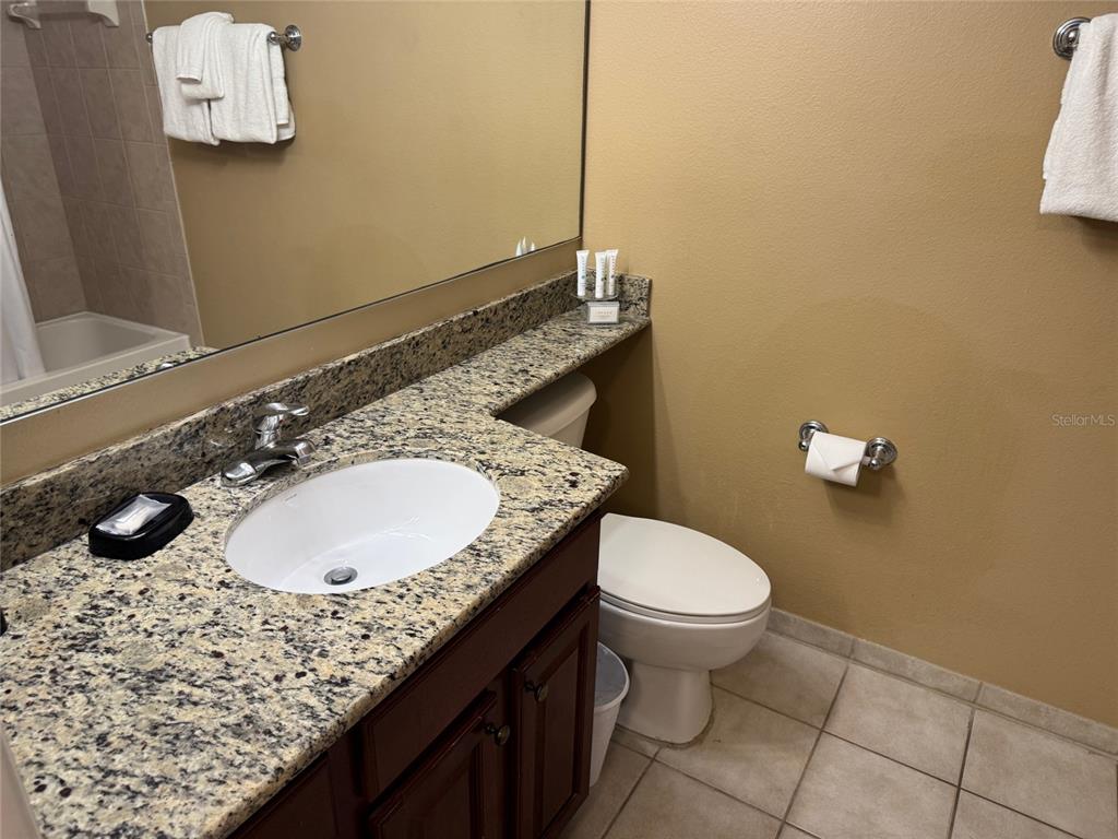 8762 Worldquest Boulevard, Unit 6203 Orlando, FL 32821 - Photo 14 of 31 a bathroom with a granite countertop sink and a mirror