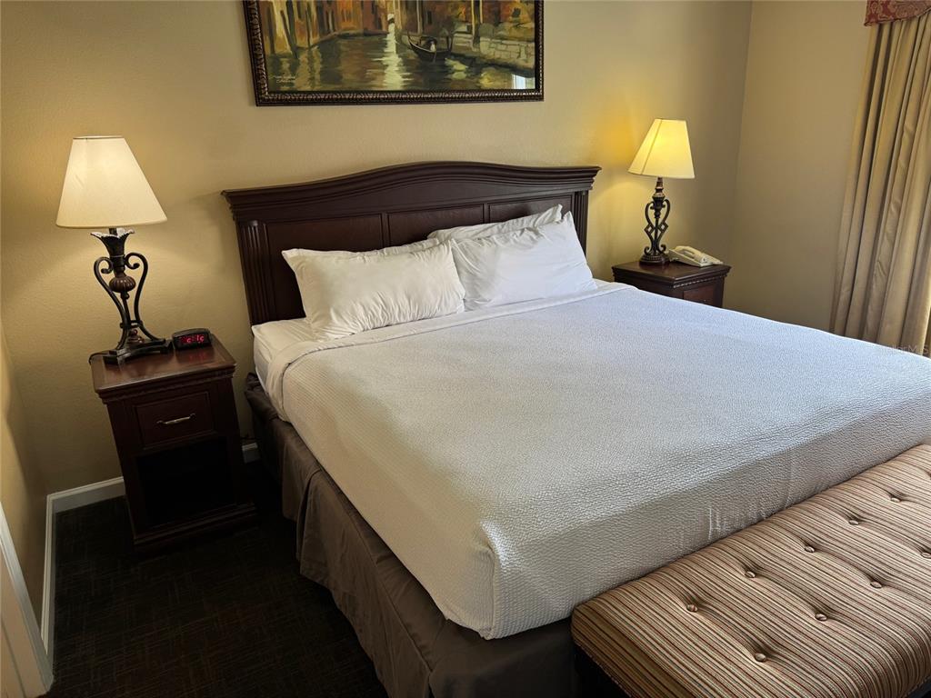 8762 Worldquest Boulevard, Unit 6203 Orlando, FL 32821 - Photo 17 of 31 a bedroom with a bed and a lamp