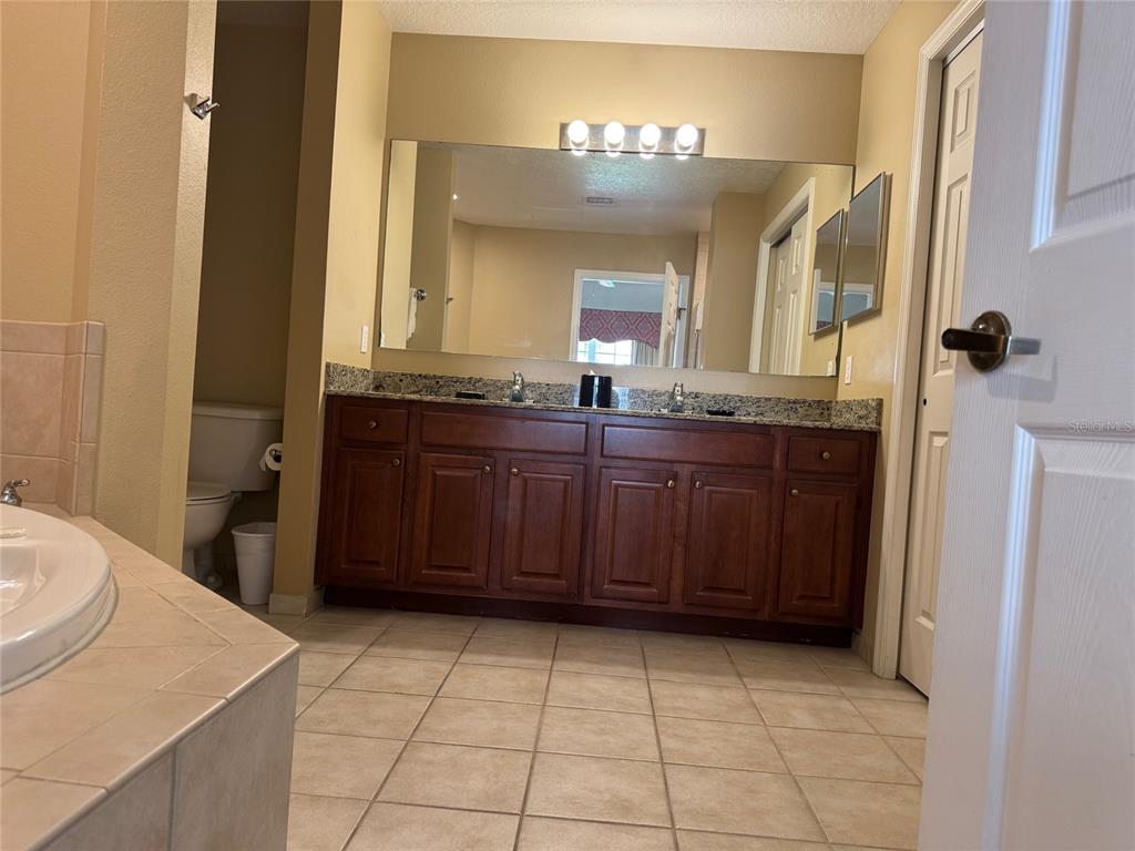 8762 Worldquest Boulevard, Unit 6203 Orlando, FL 32821 - Photo 22 of 31 a bathroom with a sink a vanity and a mirror