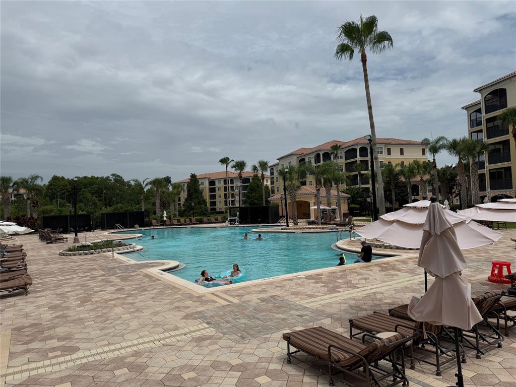 8762 Worldquest Boulevard, Unit 6203 Orlando, FL 32821 - Photo 26 of 31 a swimming pool with outdoor seating and yard