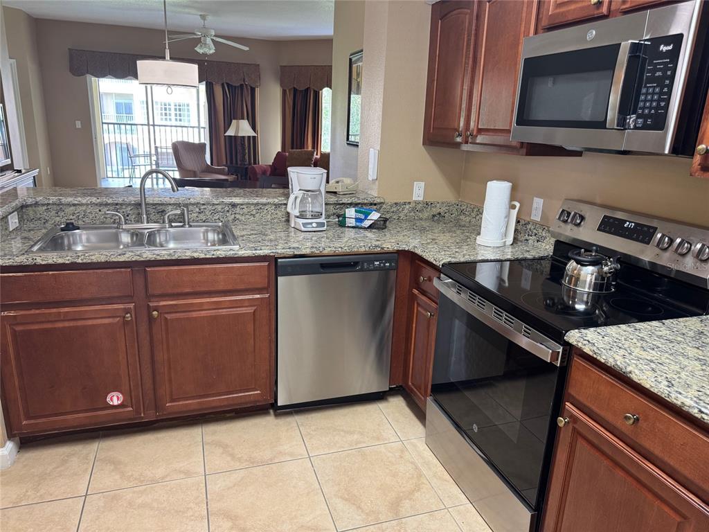 8762 Worldquest Boulevard, Unit 6203 Orlando, FL 32821 - Photo 3 of 31 a kitchen with stainless steel appliances granite countertop a sink and a stove