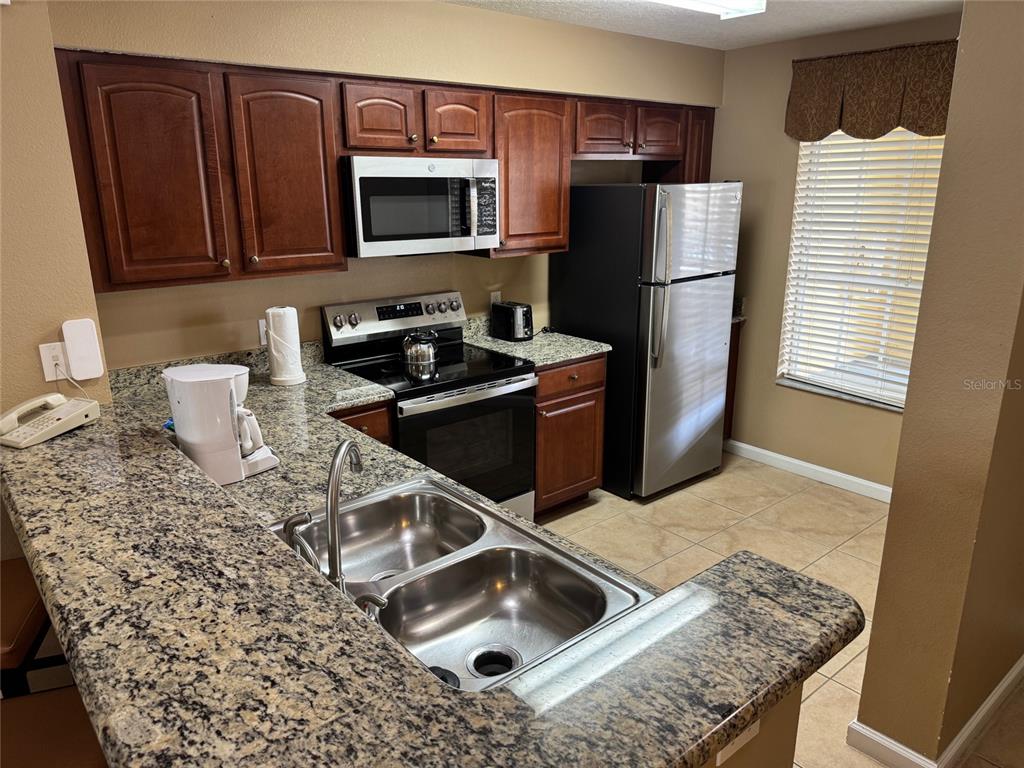 8762 Worldquest Boulevard, Unit 6203 Orlando, FL 32821 - Photo 5 of 31 a kitchen with a stove and a microwave