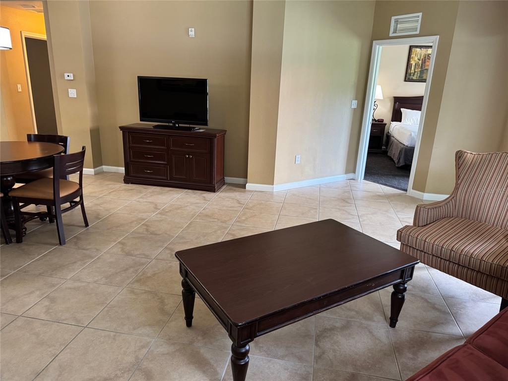 8762 Worldquest Boulevard, Unit 6203 Orlando, FL 32821 - Photo 9 of 31 a living room with furniture and a flat screen tv
