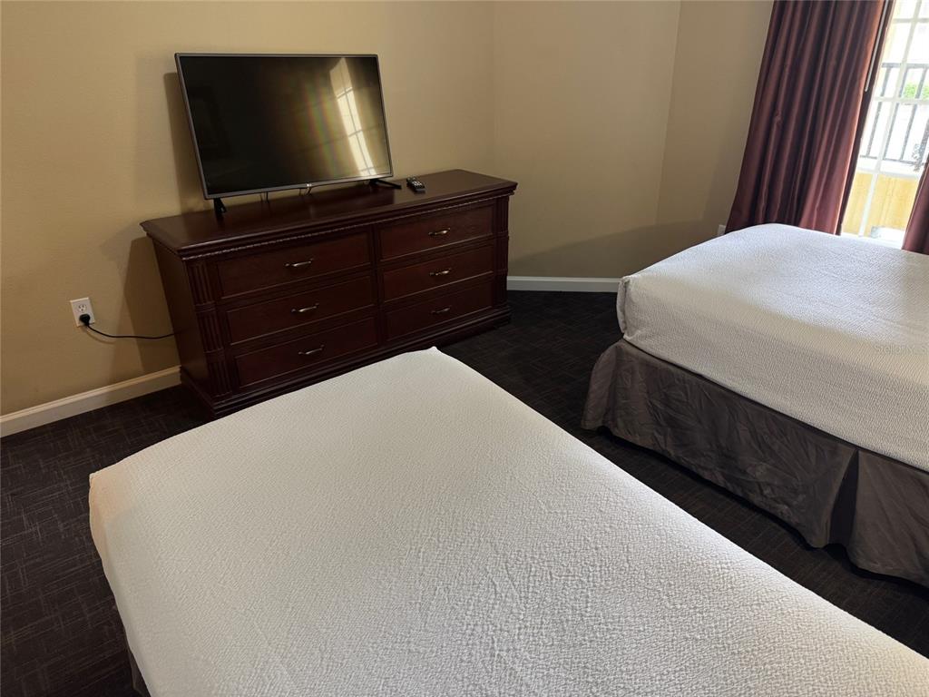 8762 Worldquest Boulevard, Unit 6203 Orlando, FL 32821 - Photo 10 of 31 a bedroom with a bed and a flat screen tv