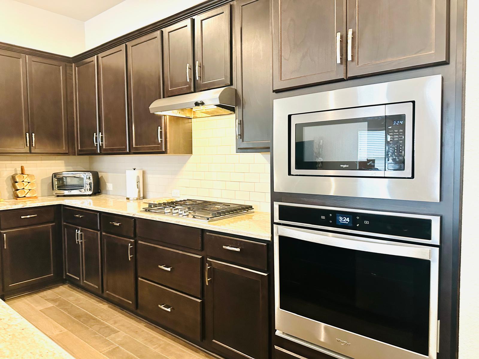 862 Leadtree Loop Buda, TX 78610 - Photo 13 of 40 a kitchen with wooden cabinets and a stove top oven