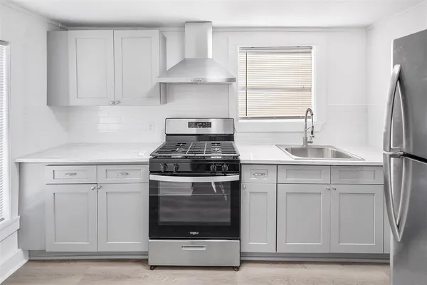 a kitchen with white cabinets and a stove