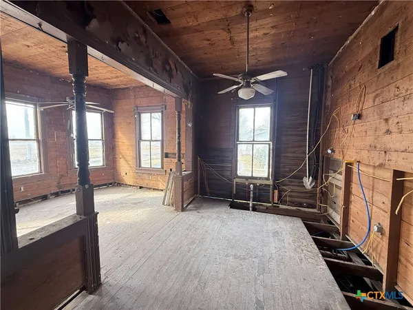 a view of an empty room with a fireplace and a window