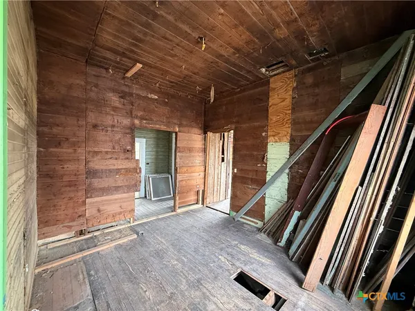 a view of a hallway with wooden floor and a chandelier