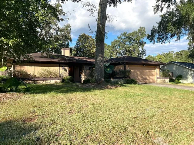 a front view of a house with a garden and yard