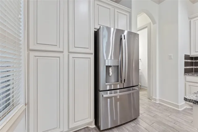 a view of kitchen with cabinets and refrigerator