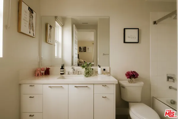 a bathroom with a sink mirror vanity and toilet