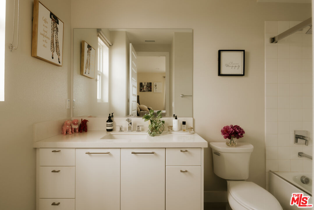 11773 Greenwood Drive Porter Ranch, CA 91326 - Photo 18 of 20 a bathroom with a sink mirror vanity and toilet
