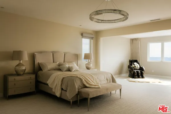 a bedroom with a bed and a chandelier