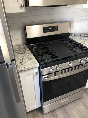 a stove top oven sitting inside of a kitchen