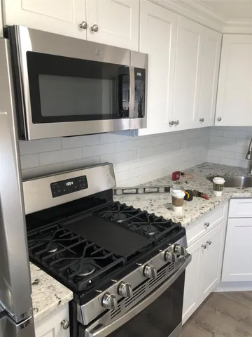 a stove top oven sitting inside of a kitchen