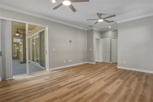 en empty room with wooden floor fan and windows