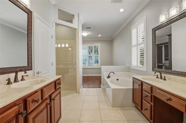 a spacious bathroom with a double vanity sink a mirror and a bathtub