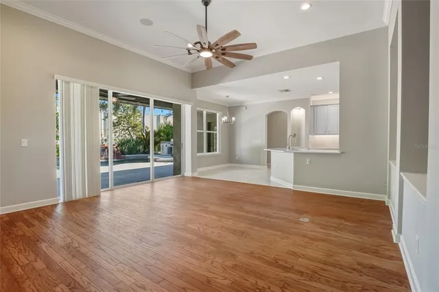 a view of an empty room with a window and wooden floor