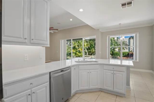 a kitchen with white cabinets and sink