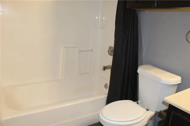 a white toilet sitting next to a bathroom sink and tub