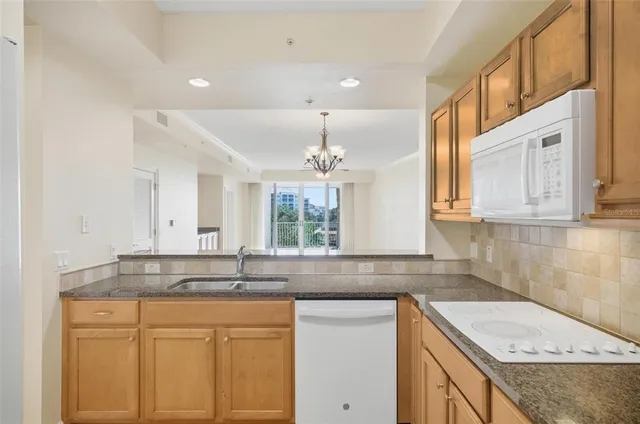 a kitchen with granite countertop a sink a stove and cabinets